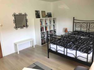 1 dormitorio con cama negra y espejo en Familienfreundliche Wohnung in Wewer, en Paderborn