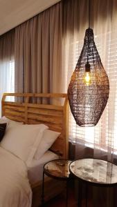 - une chambre avec un lit, un lustre et deux tables dans l'établissement Casa Basilio Studio, à Pretoria