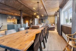 a dining room with a large wooden table and chairs at Skeikampen cabin with mountain view, jacuzzi, and 8 bedrooms in Aulstad