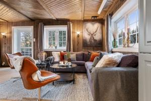 sala de estar con sofá y sillas en Skeikampen cabin with mountain view, jacuzzi, and 8 bedrooms, en Olstad