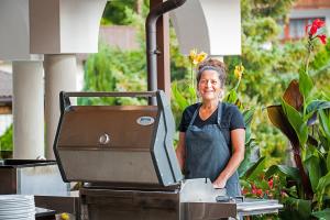 Eine Frau, die vor einem Grill steht. in der Unterkunft Hotel-Restaurant Sonnhof in Radfeld