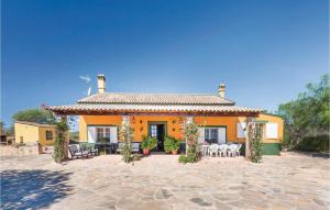 コンスタンティナにあるCozy Home In Constantina With Outdoor Swimming Poolのパティオが目の前にある大きなオレンジ色の家です。