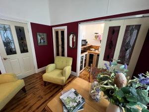 a living room with a couch and a chair at Ivy May Cottage in Lakes Entrance