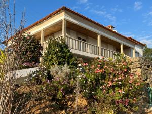 uma casa com flores em frente em Cerdeirinhas de basto Hospedagem em Canedo de Basto