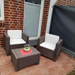 two chairs and a table on a patio at Appartment am Fingerhut in Cloppenburg
