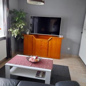 a living room with a tv and a table at Appartment am Fingerhut in Cloppenburg