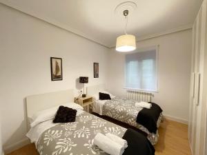 a bedroom with two beds and a window at LORE - Parking y bicis gratis in San Sebastián