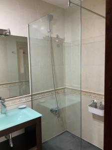 een badkamer met een glazen douche met wastafel bij Finis Viae in Fisterra +9 foto's