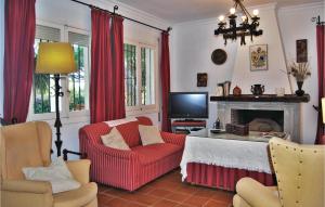 een woonkamer met een rode stoel en een open haard bij Awesome Home In Mazagn With Wifi in Mazagón