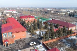 une vue aérienne sur un bâtiment avec un toit rouge dans l'établissement El-Tau, à Ekibastuz