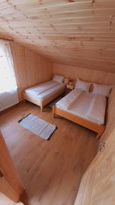 2 camas en una habitación con techo de madera en Pensiunea Valea Tonii en Strungari