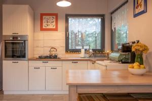 a kitchen with white cabinets and a window at Szary domek Zelwa in Zelwa