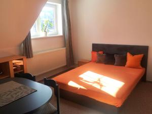 Ubytování Kuncovi في بيدريتشوف: غرفة نوم مع سرير وملاءات برتقالية ونافذة