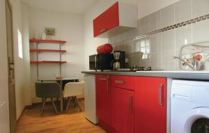 バスティアにあるAmazing Apartment In Bastia With 1 Bedrooms And Wifiの赤いキャビネットとテーブル付きのキッチンが備わります。