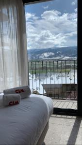 een bed in een kamer met een groot raam bij CIM HOTEL BOUTIQUE in Puigcerdà