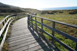 een houten promenade die naar het strand leidt bij Finis Viae in Fisterra