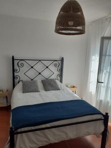 1 dormitorio con 1 cama con cabecero negro y lámpara en Porta Reguengos - Apartamento moderno Alentejo central, en Reguengos de Monsaraz