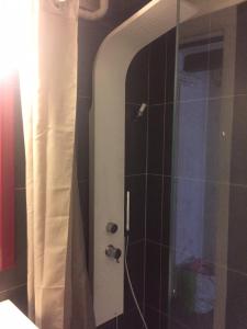 La salle de bains est pourvue d'une douche avec une porte en verre. dans l'établissement Victor Hugo 3D et sa pizza offerte, à Aurillac