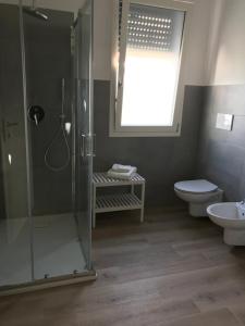 a bathroom with a shower and a toilet and a sink at Casa via Garibaldi in Leverano