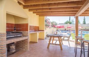 una cocina al aire libre con mesa y chimenea en 4 Bedroom Beautiful Home In Llria, en Liria