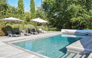 a swimming pool with two chairs and an umbrella at 1 Bedroom Awesome Home In Sembas in Sembas