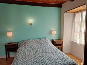a blue bedroom with a bed and two night tables at Maison spacieuse à Florentin-la-Capelle avec jardin 70 m² in Florentin-la-Capelle