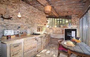 a kitchen with a table and a stone wall at Cozy Home In Saignon With Kitchen in Saignon