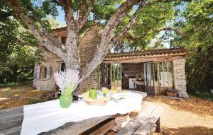 a table with a white table cloth sitting under a tree at Cozy Home In Saignon With Kitchen in Saignon