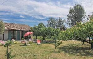 een huis met een tuin met bomen en een rode paraplu bij Beautiful Home In St, Julien De Peyrolas With Wifi in Aiguèze