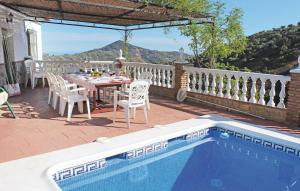 a patio with a table and chairs next to a pool at Lovely Home In Corumbela With House A Mountain View in Corumbela