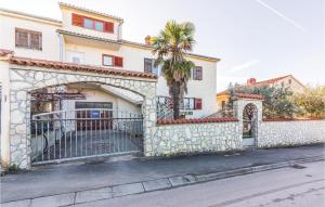 a house with a gate and a palm tree at Cozy Apartment In Vodnjan With Wifi in Vodnjan