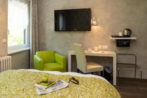 une chambre d'hôtel avec un lit, une chaise et une table dans l'établissement Logis Hotel Des Vosges, à Sewen