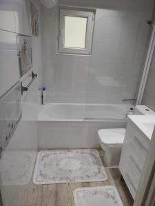 baño blanco con bañera, aseo y lavamanos en Bianca Home en Castellón de la Plana