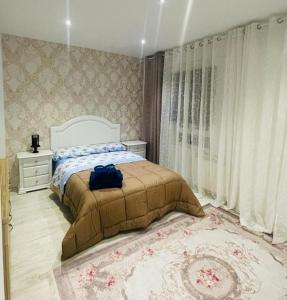 Un dormitorio con una cama con una bolsa azul. en Bianca Home en Castellón de la Plana
