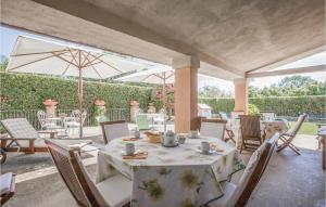 a patio with a table and chairs and umbrellas at Villa Loreto in Soriano nel Cimino