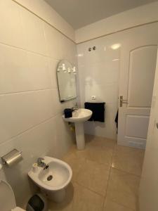 een witte badkamer met een wastafel en een toilet bij APARTAMENTO PUERTITO DE GUIMAR TEO in Puertito de Güímar