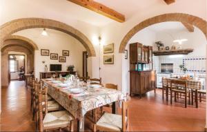 a large dining room with a long table and a kitchen at La Tana in Crespina