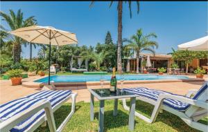 - une terrasse avec 2 chaises et une table avec une bouteille de vin dans l'établissement Lovely Home In La Marina, Elche With Outdoor Swimming Pool, à La Marina