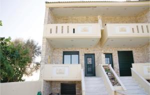 biały ceglany dom z białymi schodami i drzwiami w obiekcie Beautiful Home In Diakopto Achaias P, With Kitchen w mieście Diakopto