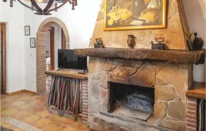 sala de estar con chimenea de piedra y TV en Awesome Home In Villanueva De La Conc, With Kitchen en La Joya