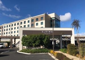 a building with a parking lot in front of it at Sudima Auckland Airport in Auckland