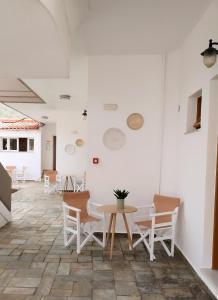 Habitación blanca con mesa y sillas en Idomeneas Apartments, en Sougia