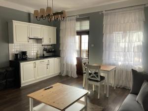 a living room with a table and a kitchen at Villa Akant - Apartamenty w Karkonoszach in Piechowice