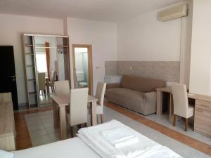 Una sala de estar con un sofá, una mesa y sillas. en Lovely Home Rooms Center, en Mostar