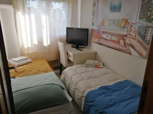 mały pokój z 2 łóżkami i telewizorem w obiekcie Casa Giardino sul Mare w mieście Grottammare