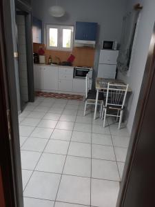 a kitchen with a white tiled floor and a table at The Best Choice in Preveza +10 photos
