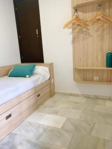 - une chambre avec un lit et une armoire en bois dans l'établissement Apartamento Vip la Barrosa, à Chiclana de la Frontera