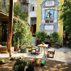 eine Terrasse mit einem Tisch und einem Schild an einem Gebäude in der Unterkunft Tirana Backpacker Hostel in Tirana