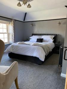 1 dormitorio con 1 cama grande y cabecero negro en Ivy House, three bed cottage, parking garden, en Skipsea