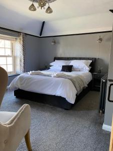 une chambre avec un grand lit avec une tête de lit noire dans l'établissement Ivy House, three bed cottage, parking garden, à Skipsea